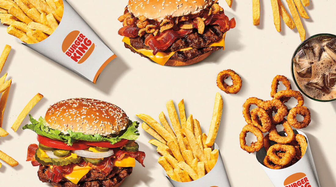 Fries, burgers, onion rings, and a drink.