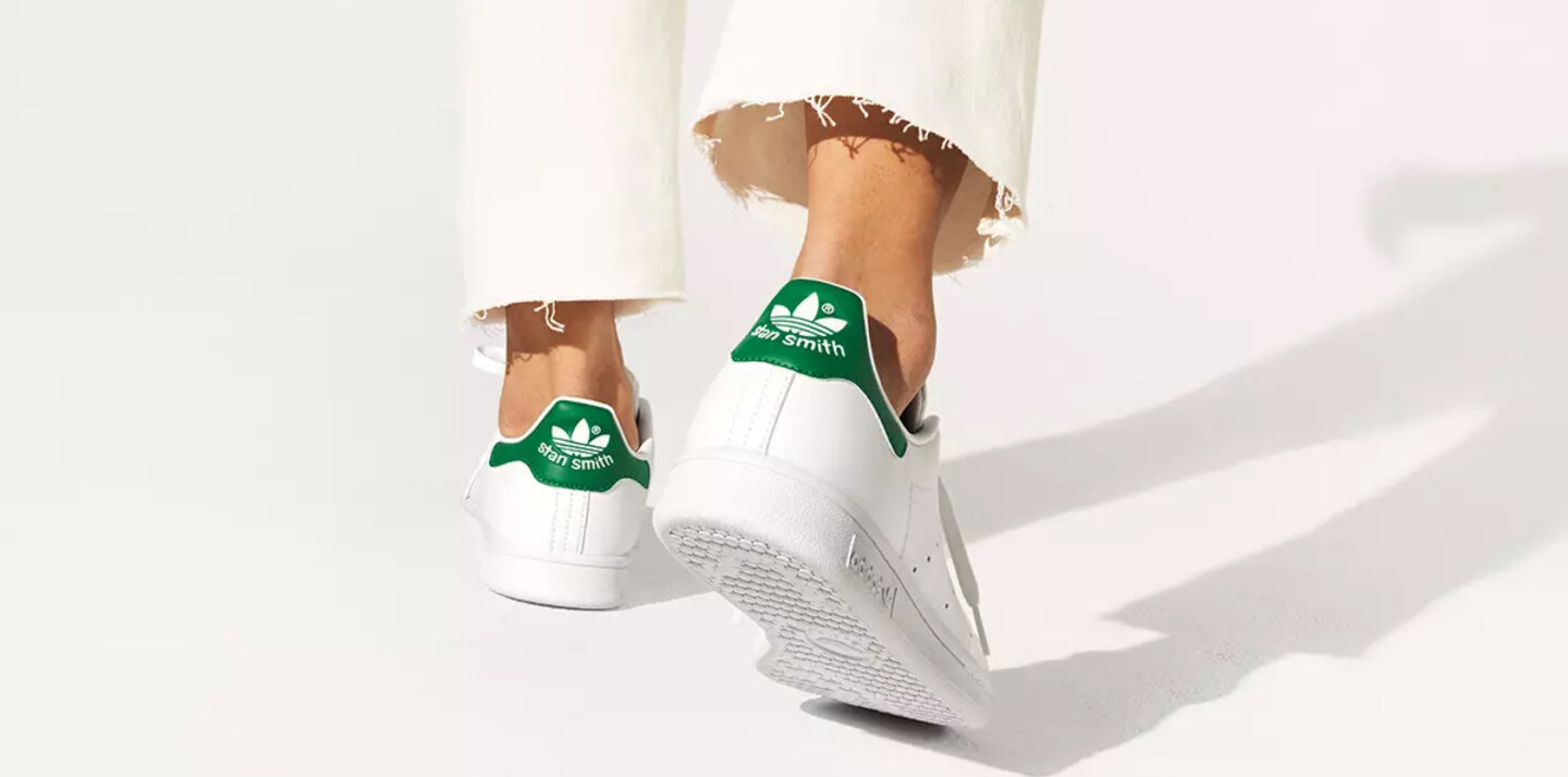 White Adidas sneakers with a green elements.