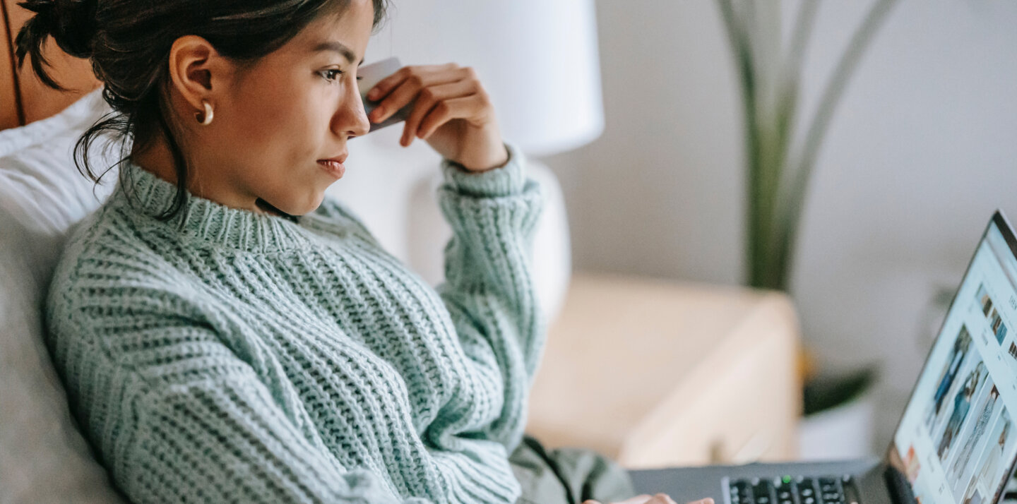 A woman in a blue jumper is checking the BaseLinker website.