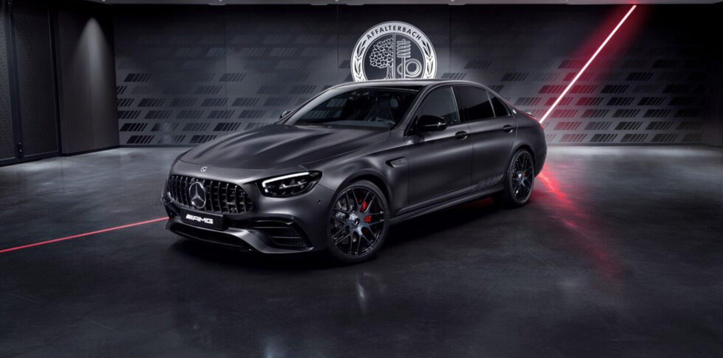 A black Mercedes car parked in a dark room with a streak of red light behind it. A black Mercedes car parked in a dark room with a streak of red light behind it.
