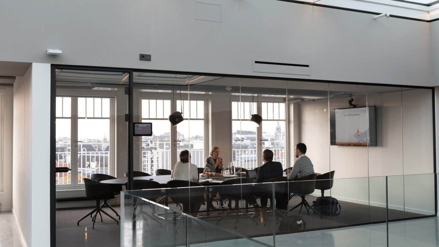 Four people sitting in a conference room. Four people sitting in a conference room.
