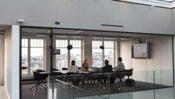 Four people sitting in a conference room. Four people sitting in a conference room.