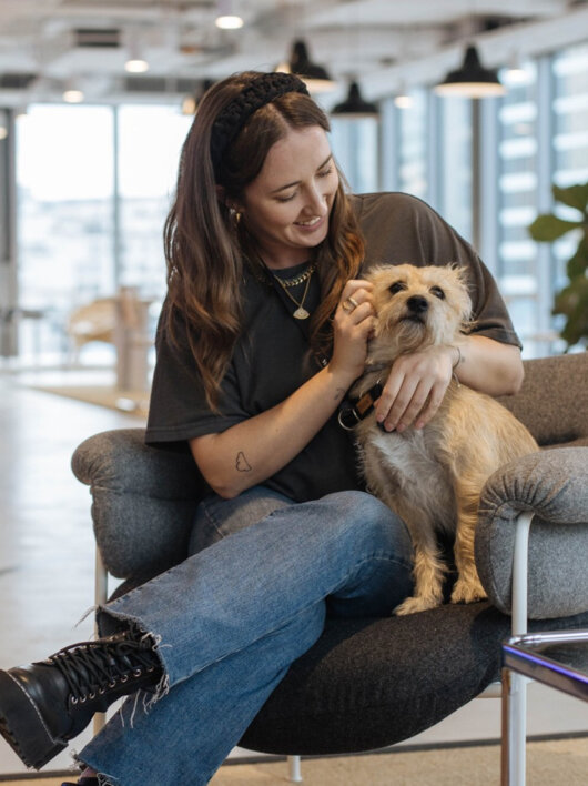 Women with the dog sitting on a chair in office space. Women with the dog sitting on a chair in office space.