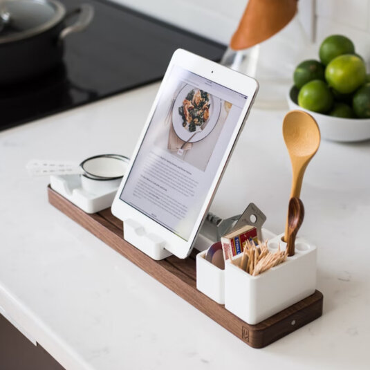 A cooking utensils organiser with a tablet stand. The tablet is open on a pasta recipe. A cooking utensils organiser with a tablet stand. The tablet is open on a pasta recipe.