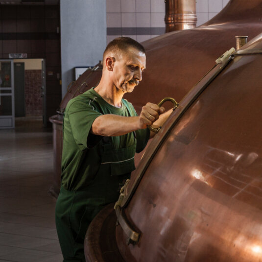 A person is brewing beer. A person is brewing beer.