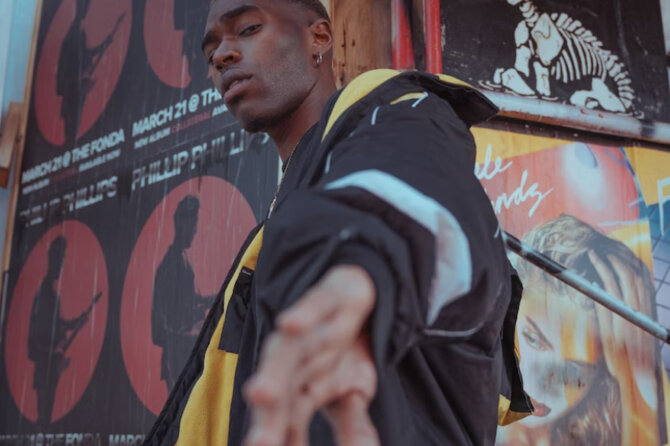 A young man is looking and reaching his hand to the camera.