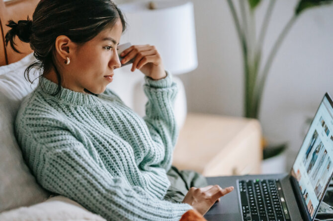 A woman in a blue jumper is checking the BaseLinker website.