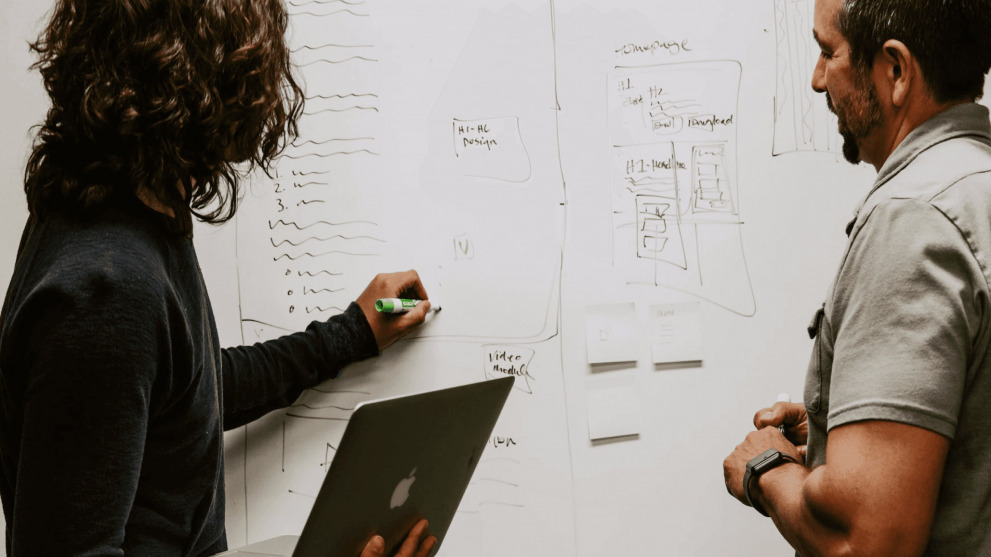 Two people discussing UX process. Two people discussing UX process.